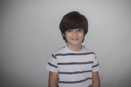 Young multiracial boy Indian-Iranian looking at camera smiling