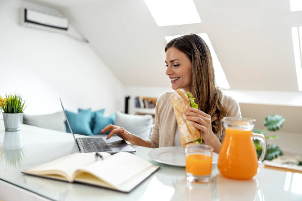istock Woman in the kitchen working on laptop 1448364558