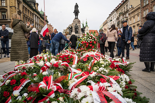Poland Independence Day in Krakow. People leaving flowers with Polish flags next to Grunwald Monument at Plac Matejki. Krakow, Poland - November 11, 2022.