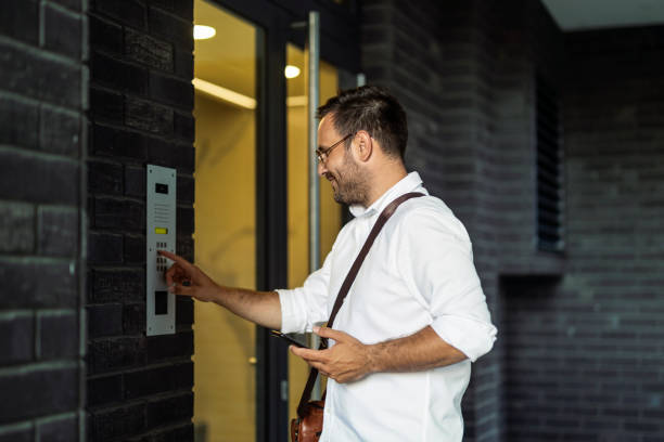 istock Young man using intercom at residential building entrance 1448366988