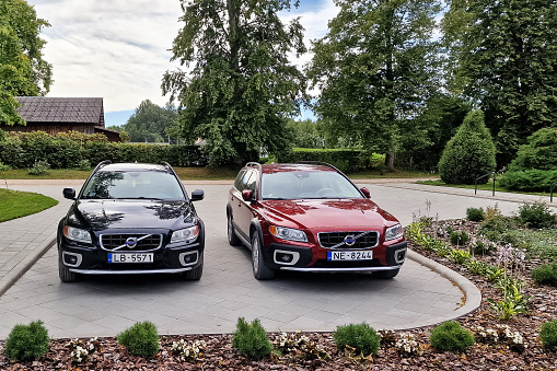Kaltene, Latvia - August 6, 2022: Two different colored Volvo XC70 cars are parked next to it.