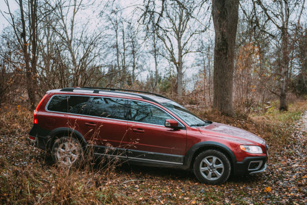 nogale, letonia - 5 de noviembre de 2022: automóvil volvo xc70 rojo junto a la carretera rural. - editorial eastern europe europe reflection fotografías e imágenes de stock