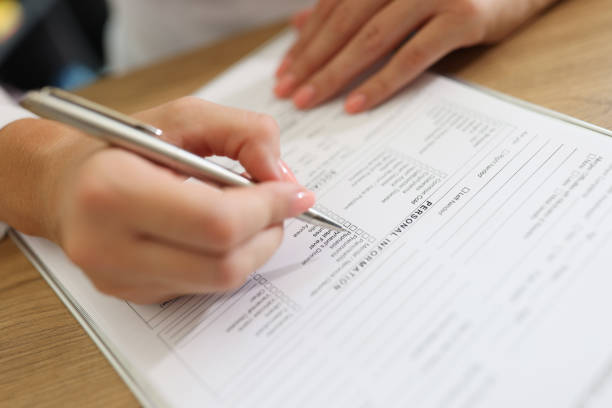 Woman patient filling medical form in clinic stock photo