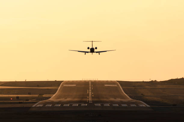 Small airplane in flight taking off at sunset stock photo