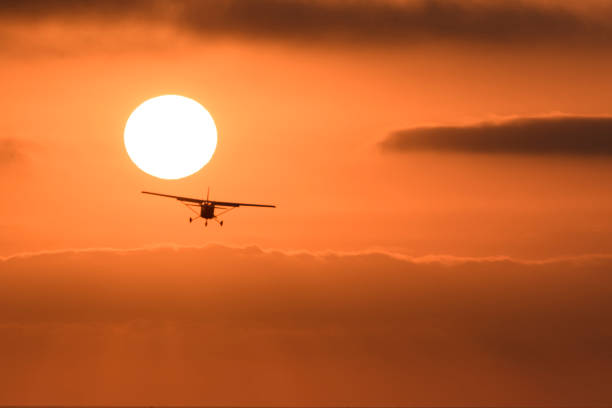 Small airplane single propeller in flight taking off at sunset stock photo