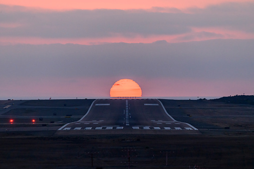 Sun setting behind airport runway