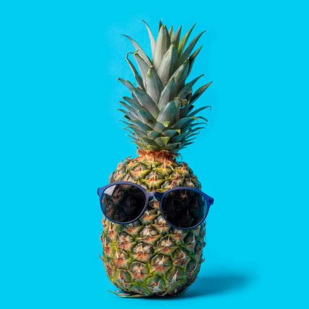 istock Trendy hipster pineapple fruit with sunglasses on a blue background. Summer time vacation holiday healthy concept 1448374045