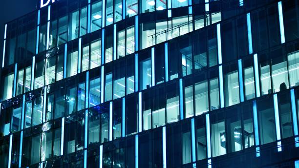 istock Pattern of office buildings windows illuminated at night. 1448375835