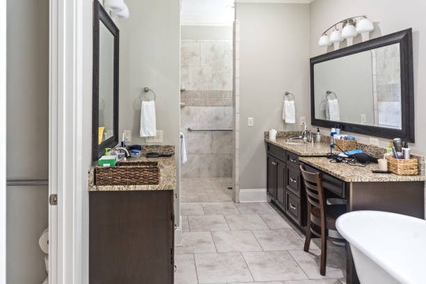 istock A large master tiled bathroom with dark wood cherry cabinets and mirrors and a freestanding bathtub 1448376096