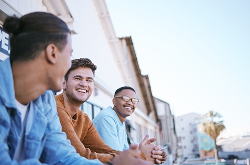 Friends on balcony, London people relax in city summer sunset lifestyle and party joke by funny young man. Happy gen z men talking by terrace, outdoor apartment weekend and friendship smile together