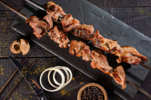 kebabs grilled meat skewers, shish kebab, on old dark wooden table background - yakitori stok fotoğraflar ve resimler