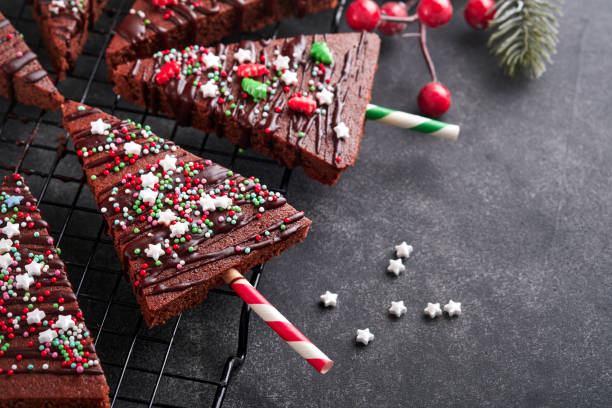 istock Chocolate brownies Christmas tree with chocolate icing and festive sprinkles on stone table. Christmas food ideas sweet homemade Christmas holidays pastry concept. Holiday cooking concept. Top view. 1448378608