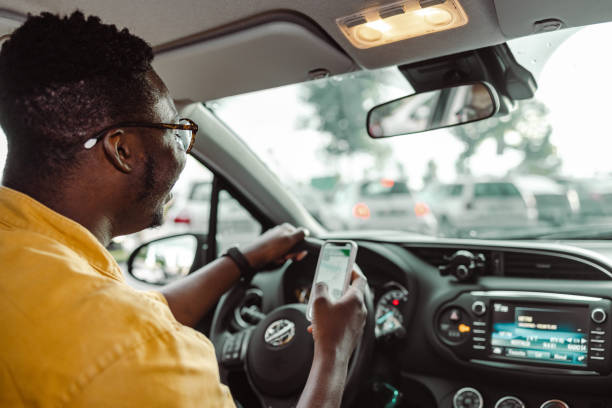 istock African-American man using smart phone while driving a car 1448382174