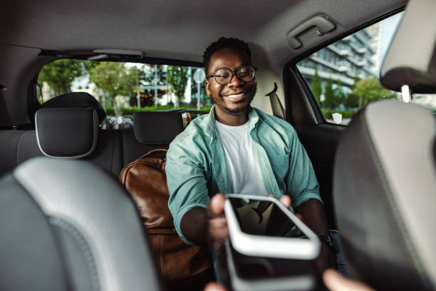 istock Young man using smart phone for paying a taxi ride 1448382549