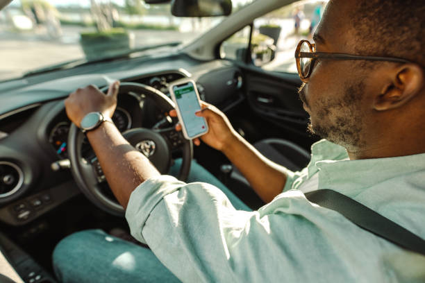 istock Young African-American man sitting using smart phone in the car 1448382627