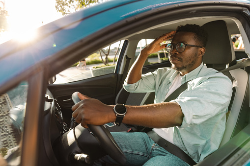 Nervous impatient African-American male driver stuck in traffic jam