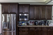 istock A modern kitchen with dark wood cabinets and stainless steel appliances 1448384459