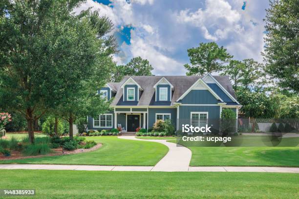 A Large Blue Craftsman New Construction House With A Landscaped Yard And Leading Pathway Sidewalk Stock Photo - Download Image Now
