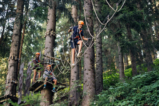 des adolescents s’amusent dans un parc d’aventure de parcours de cordes - high up obstacle course ropes course teenage boys photos et images de collection