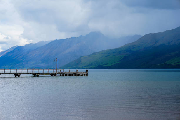 Wooden dock in a mountain alpine lake on a cloudy day in Glenorchy New Zealand