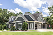 istock A large gray craftsman new construction house with a landscaped yard and leading pathway sidewalk 1448386210
