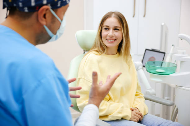 paciente rubia sentada en la silla del dentista y sonriendo - corona-dental fotografías e imágenes de stock