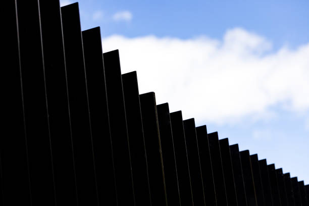 Closeup black metal fence against blue sky background with copy space, full frame horizontal composition