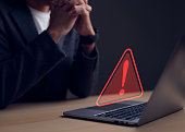 Computer notification error maintenance concept. Businessman or personnel, programmer, or developer using a computer laptop with a triangle warning exclamation red sign trouble caution.