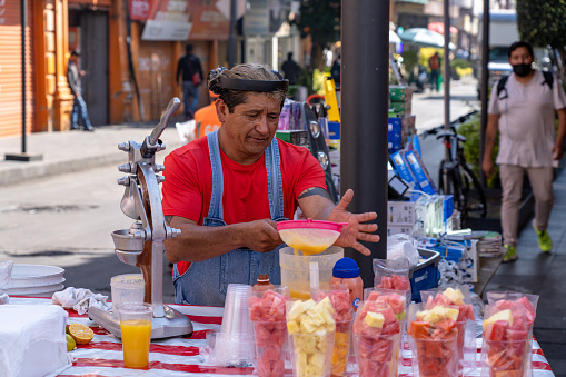 Mexico City, Mexico - February 15 2022: Street vender making juice drinks in Mexico City