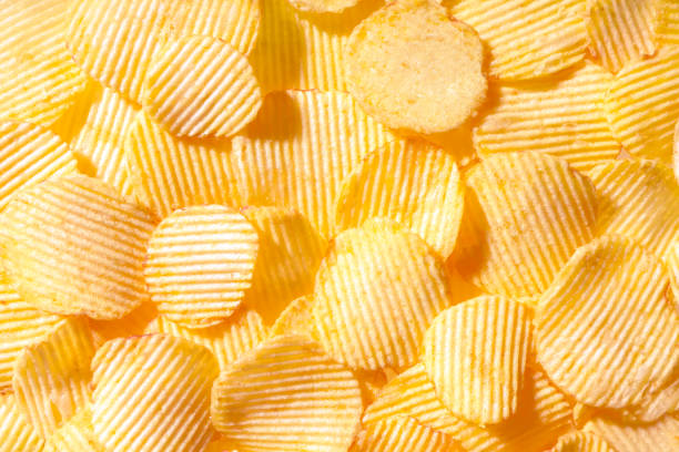 istock Yellow crispy ridged potato chips close up. Food background 1448391123