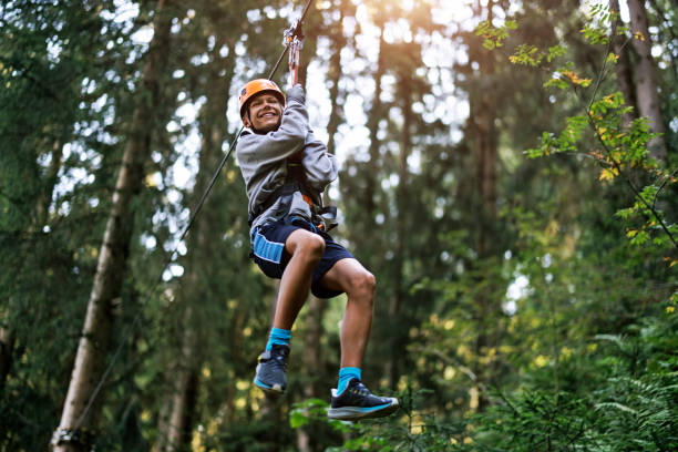 des adolescents profitent du parcours d’accrobranche dans une forêt - high up obstacle course ropes course teenage boys photos et images de collection