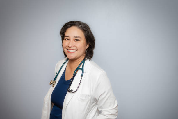 istock Studio Portrait - Female Doctor - Soft Grey Background - Positive Emotion - White Coat 1448391227