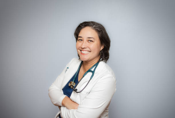 istock Studio Portrait - Female Doctor - Soft Grey Background - Positive Emotion - White Coat 1448391235