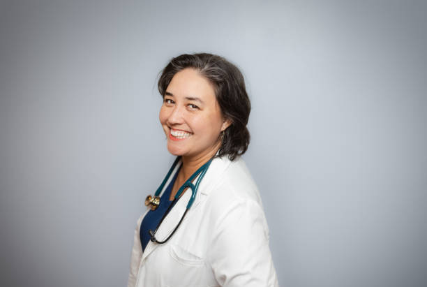istock Studio Portrait - Female Doctor - Soft Grey Background - Positive Emotion - White Coat 1448391244
