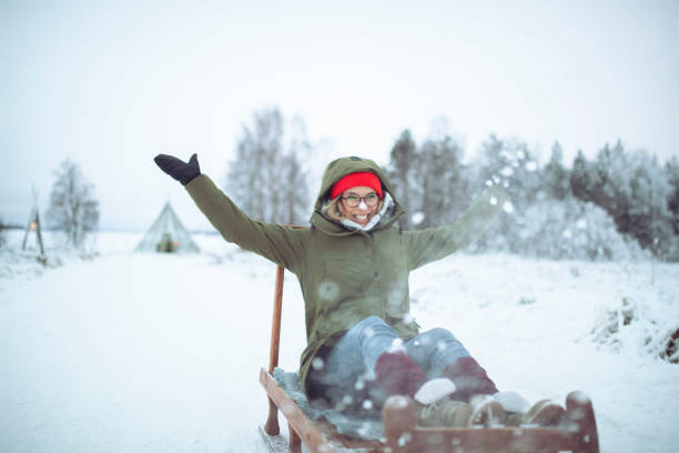 istock A happy woman is sledding and throwing snow, a winter idyll 1448393476