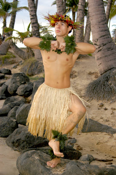 istock Male hula dancer poses in front of palm trees on the beach. 1448393668
