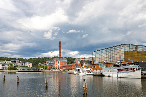 August, 2022. Lahti, Finland. Old steam boats in the harbour of Lahti. Sibelius concert hall and old factory in the background.