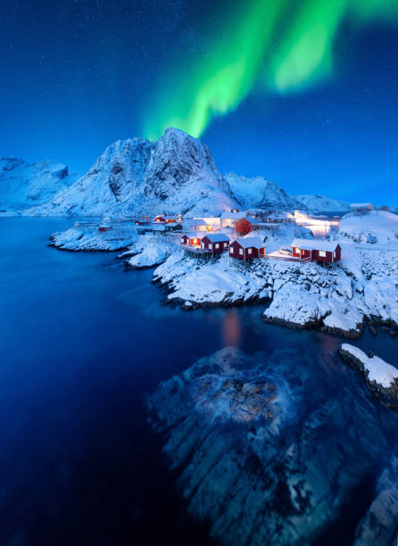 aurora boreal. aurora boreal. vista de la casa en el pueblo de hamnoy, islas lofoten, noruega. paisaje en invierno. montañas y agua. - norte de noruega fotografías e imágenes de stock