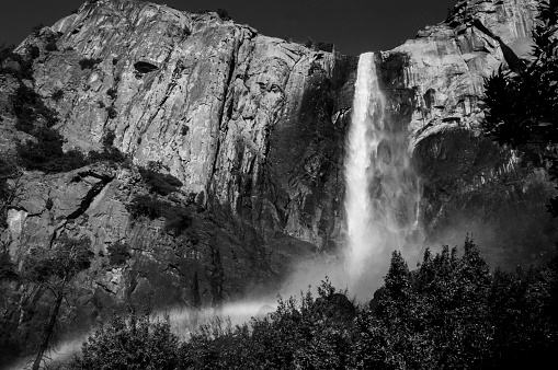 A black and white photo of Bridalveil Falls taken from the footpath leading to the base