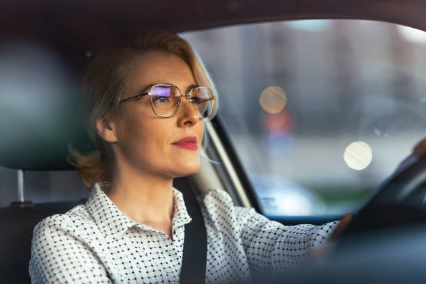 istock Smiling Businesswoman Driving Car 1448400399
