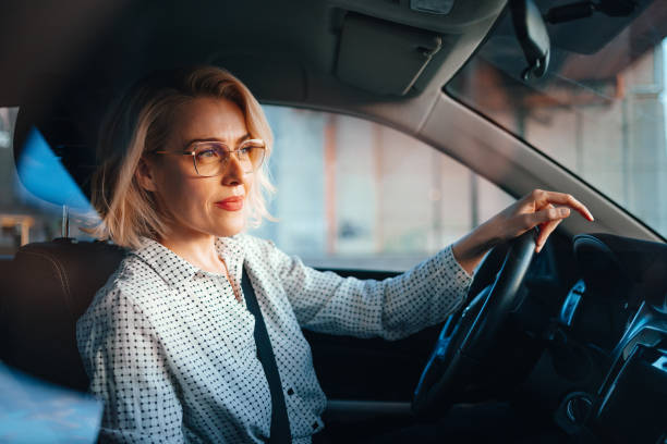 istock Smiling Businesswoman Driving Car 1448400424