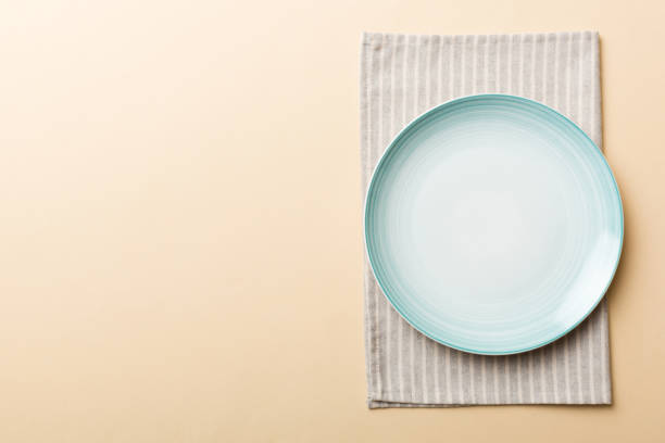 istock Top view on colored background empty round blue plate on tablecloth for food. Empty dish on napkin with space for your design 1448400508