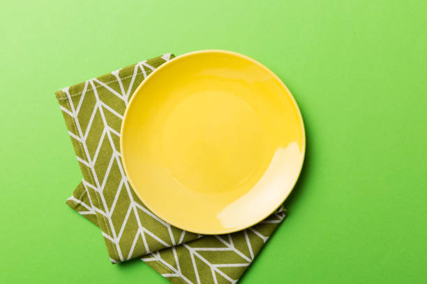 istock Top view on colored background empty round yellow plate on tablecloth for food. Empty dish on napkin with space for your design 1448400511