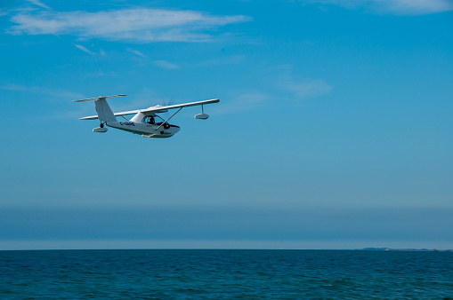 A small plane flies over Lake Erie on a sunny day