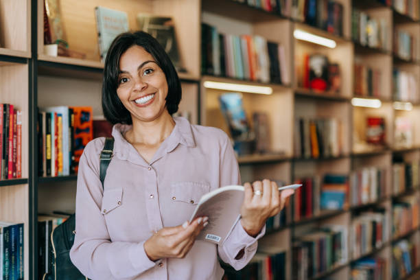 istock College student holding a book in the bookstore 1448404592