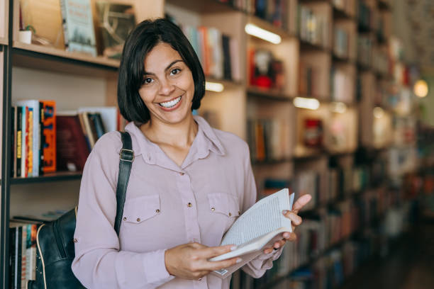 istock College student holding a book in the bookstore 1448404596