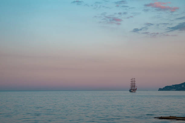 Sailboat in the sea in the evening sunlight over beautiful big mountains background, luxury summer adventure, active vacation in Mediterranean sea. High quality photo