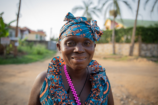 Portrait of a smiling middle aged african woman outside outdoors.