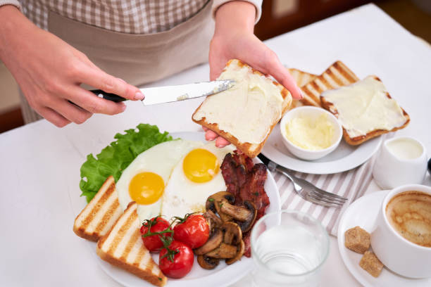 istock Fried eggs, bacon, tomato, toasted bread in white ceramic plate and cup of coffee 1448407831
