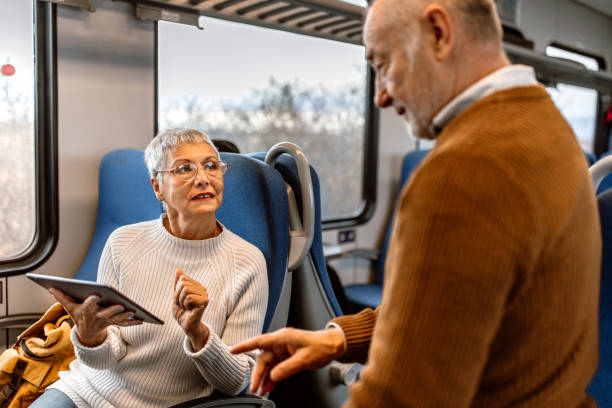 istock Senior couple using technology in train car.  Mature man and woman using digital tablet and smart phone. 1448408511